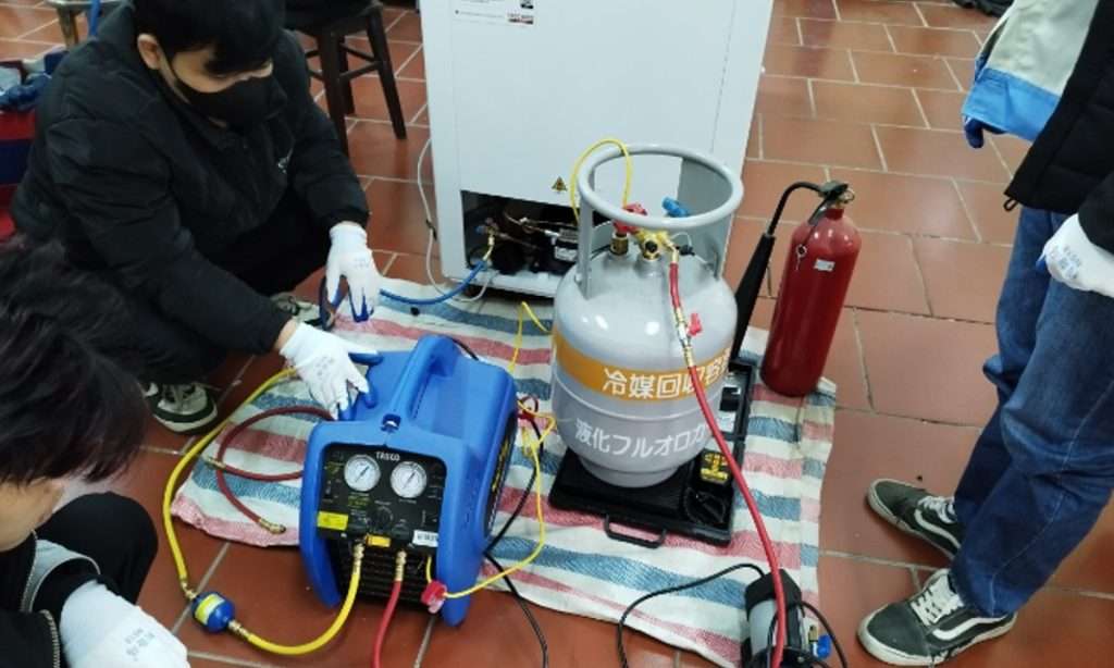 Students learning how to use a refrigerant recovery machine. (Source: HCEET)