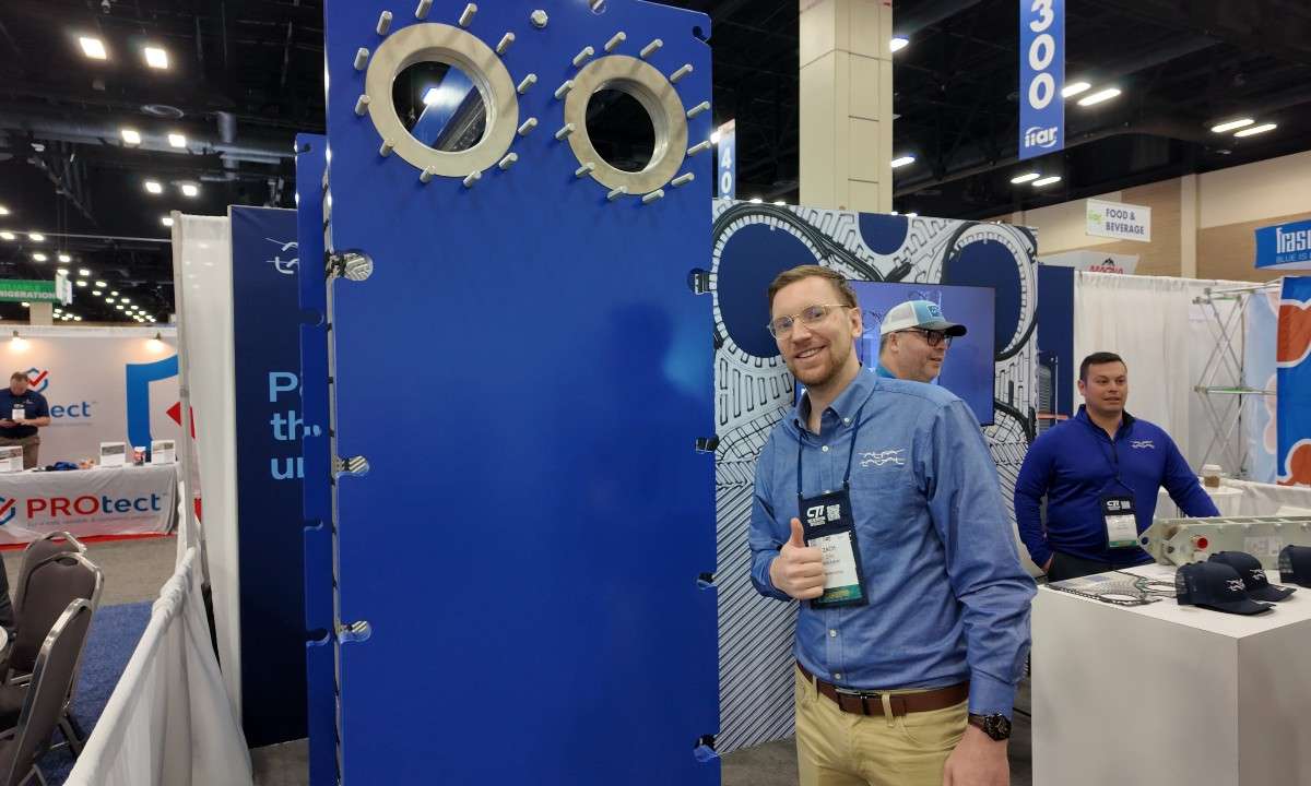 An image of Alfa Laval Refrigeration Sales Manager Zack Ellis showing off the company's T25 semi-welded plate heat exchanger for up to 1MW ammonia or cascade CO2 systems.